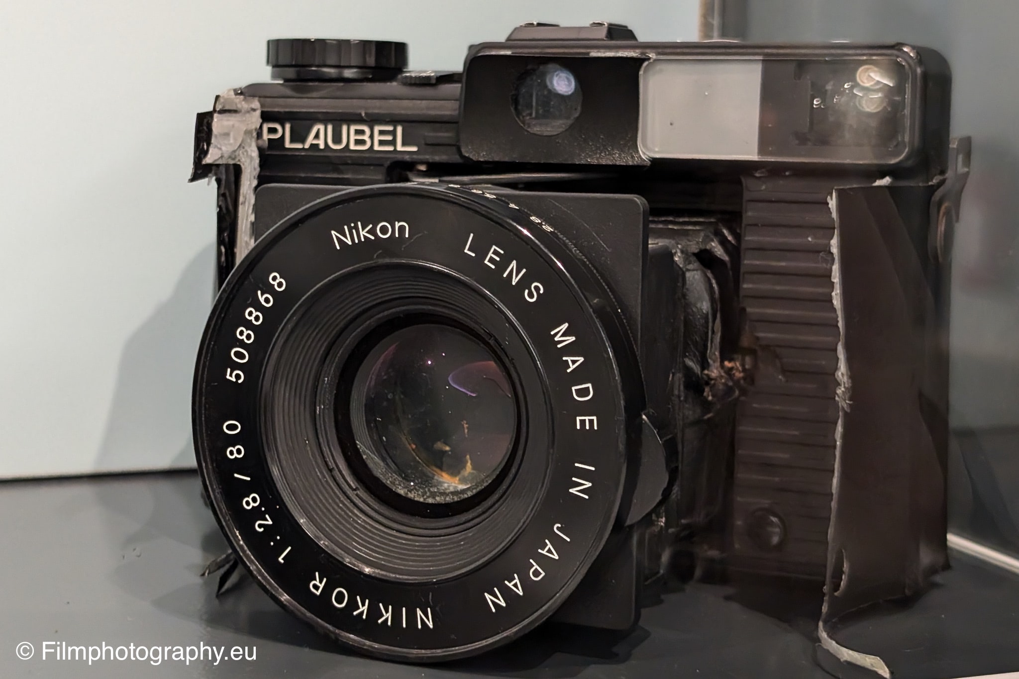 Damaged Plaubel Makina 670 medium-format camera with a Nikon lens.