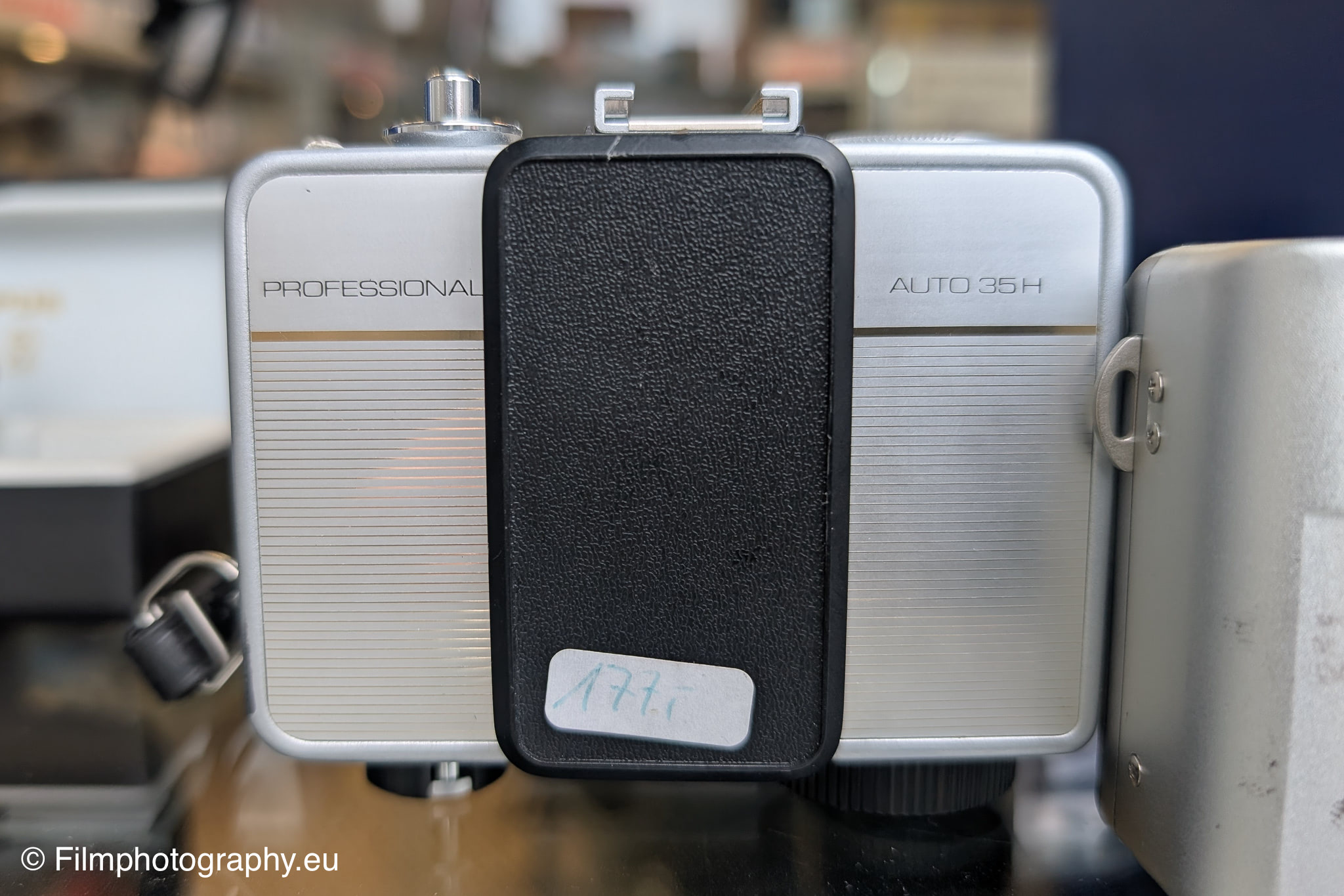Ricoh Auto 35H Professional camera, silver body with black flash attachment.