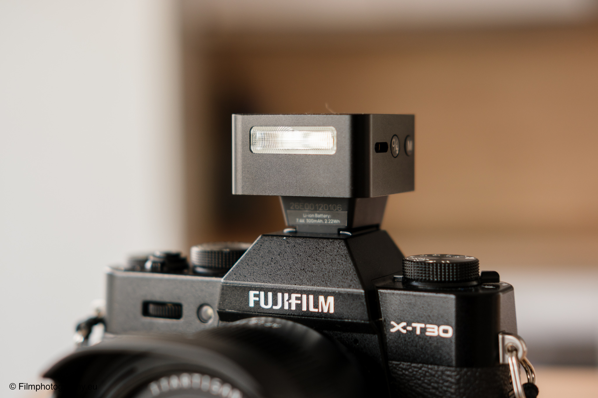 Fujifilm X-T30 spiegellose Kamera mit Zeniko ZF08 TTL-Blitz auf Hot Shoe, Nahaufnahme mit warmem weichem Bokeh-Hintergrund
